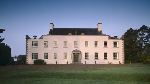 View of the East front of Ardress House, Co Armagh, Northern Ireland showing the c18th limestone portico, quoins, urns, undulating coping stones